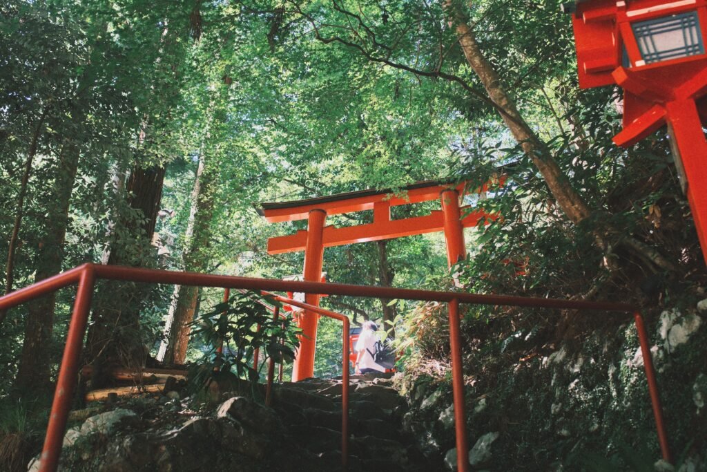 Red torii gates surrounded by lush greenery at Kifune Shrine near Kyoto