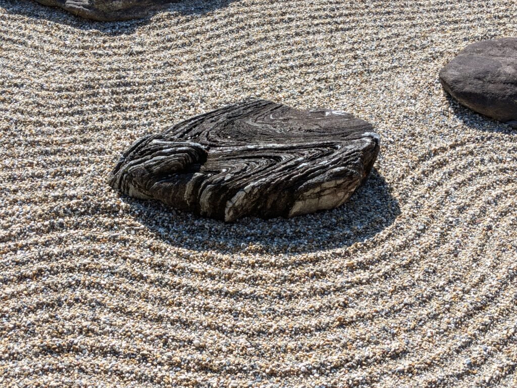 Raked gravel and stones in a serene Japanese zen rock garden