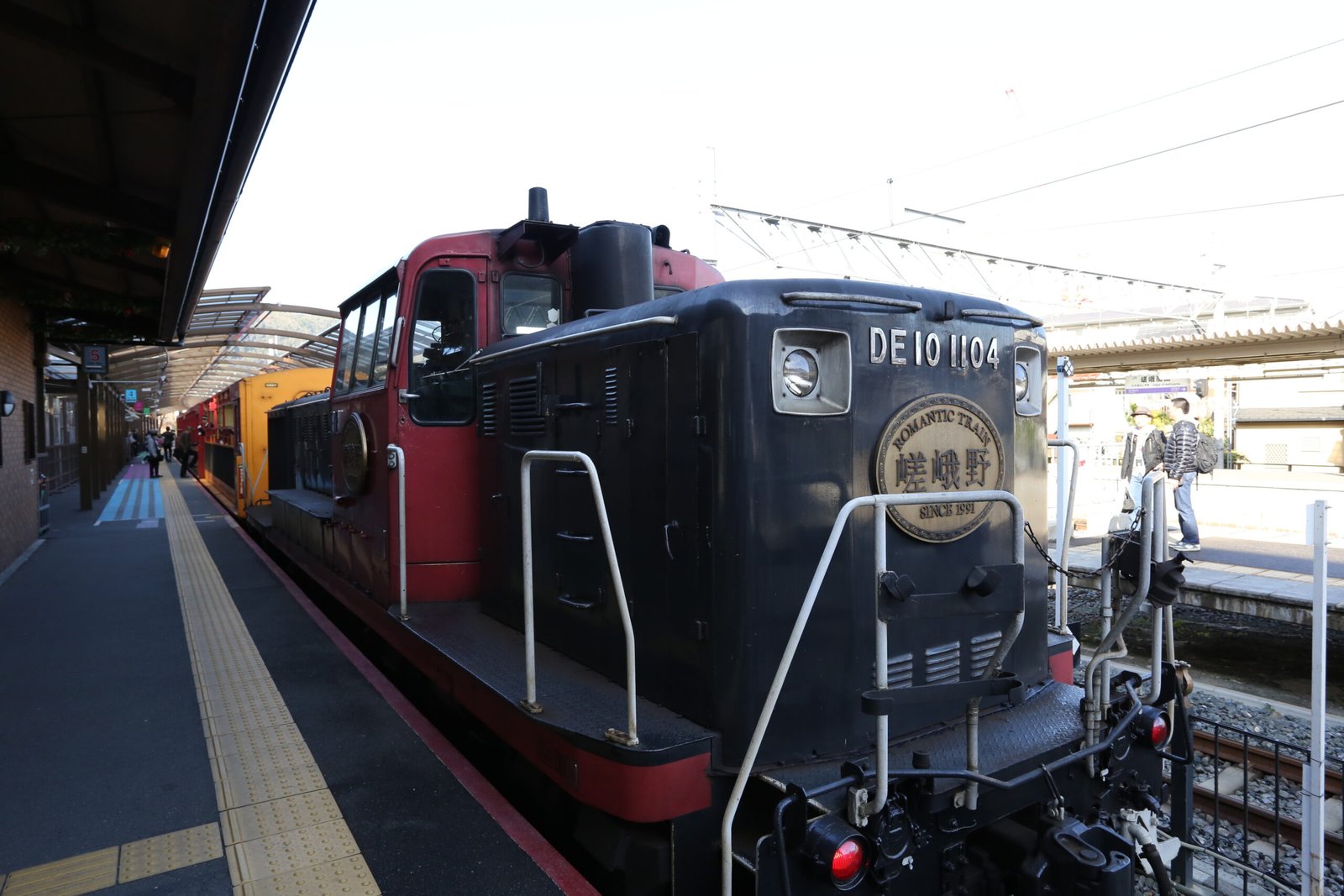 A Sagano Scenic Railway diesel locomotive pulling open-air sightseeing carriages, Kyoto